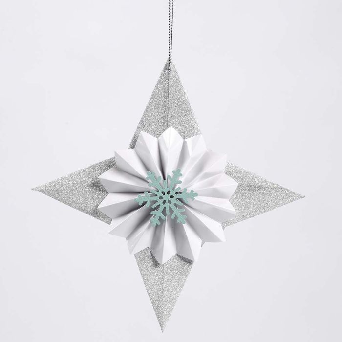 Una stella di carta glitter con una coccarda e un fiocco di neve