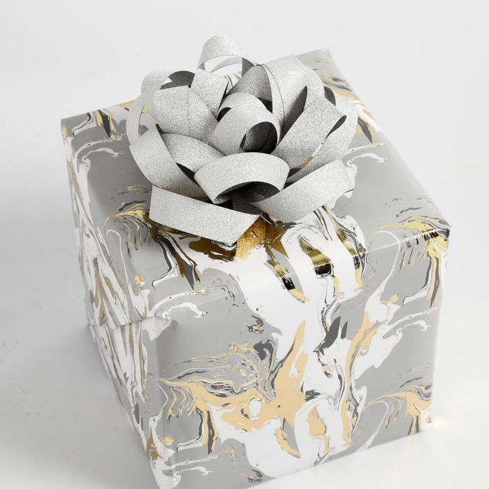 Confezione regalo decorata con una coccarda realizzata con strisce di carta per stelle