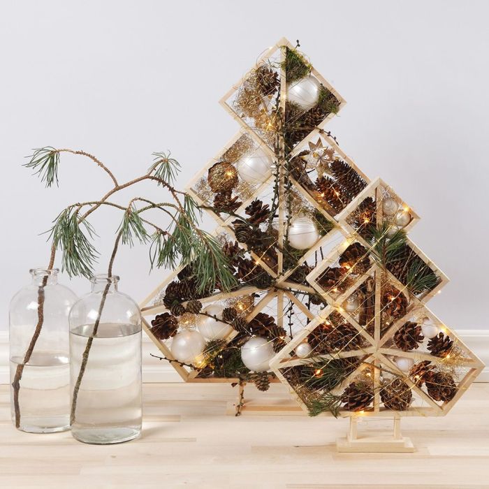 Alberi di Natale decorati con sfere natalizie, pigne, abeti e luci