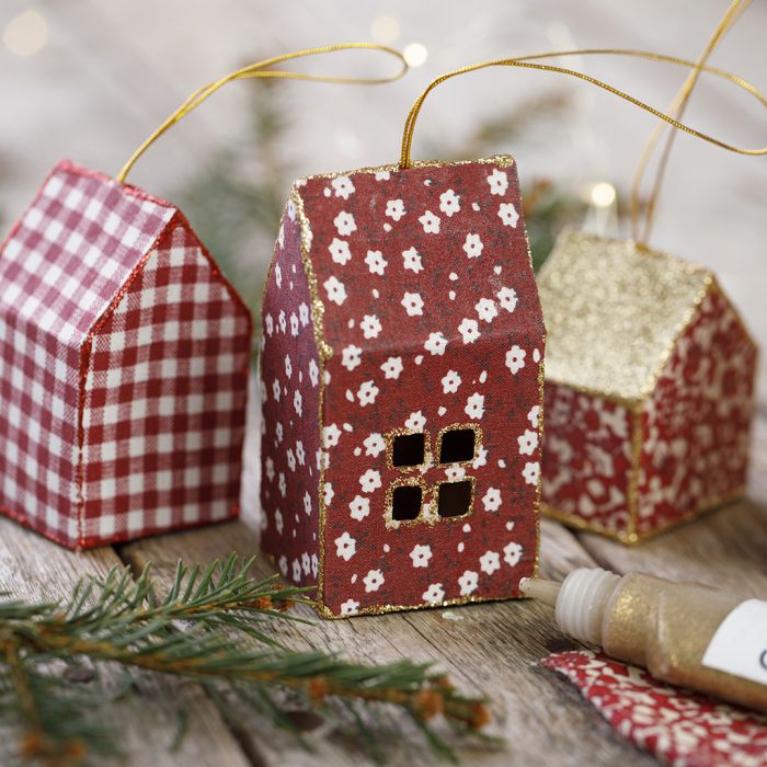 Una casa di Natale in cartoncino e stoffa decorata con glitter da appendere