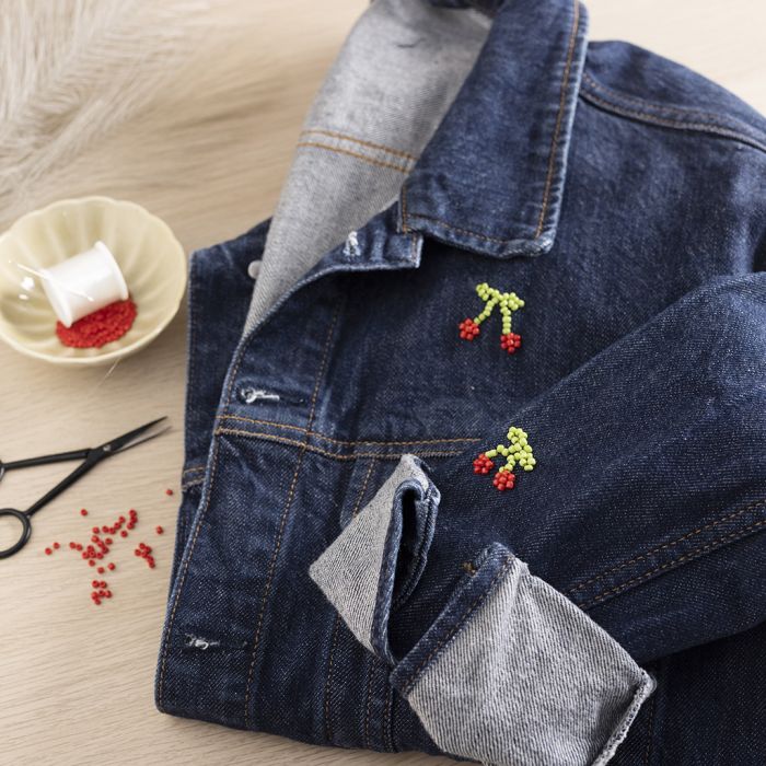 Ciliegie ricamate con perline su una giacca di jeans