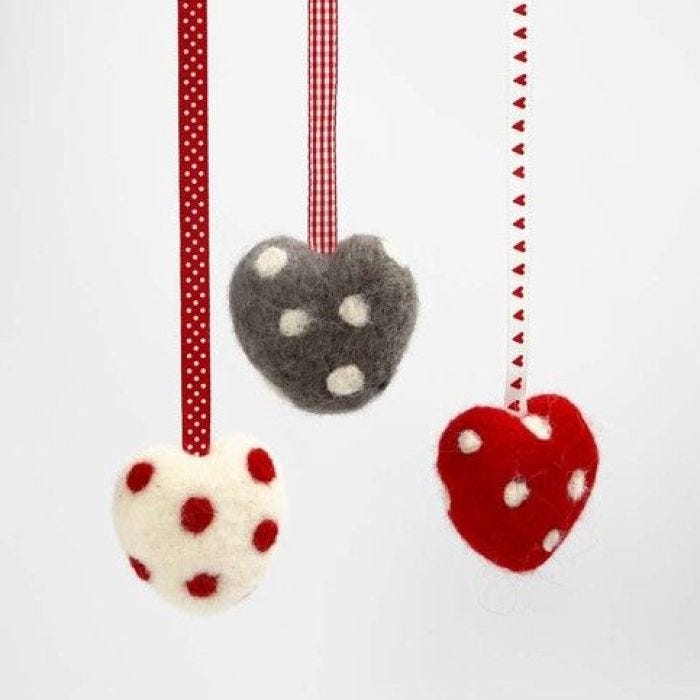 Un cuore infeltrito con pois e nastro decorativo