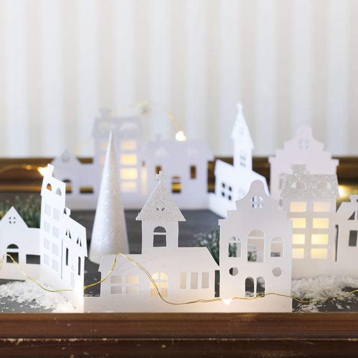 Una silhouette di città in cartoncino decorata con carta glitter e carta di velluto