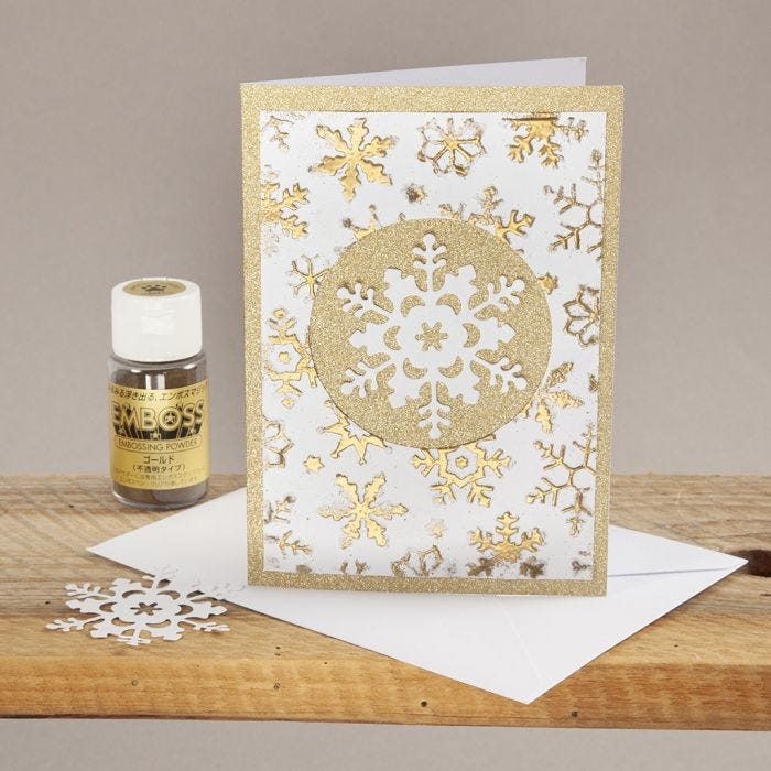 Biglietto natalizio decorato con embossing fantasia e fiocco di neve fustellato