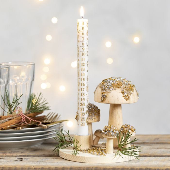 Un candelabro su base di legno con funghetti decorati con mini perline di vetro