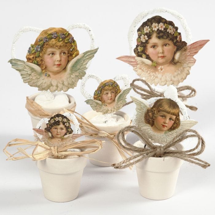 Angeli vintage fustellati in piccoli vasi da fiori