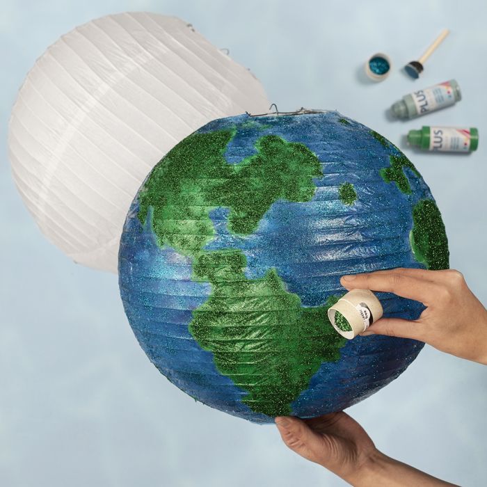 Un globo da una lampada di carta di riso decorato con vernice artigianale e glitter bio 