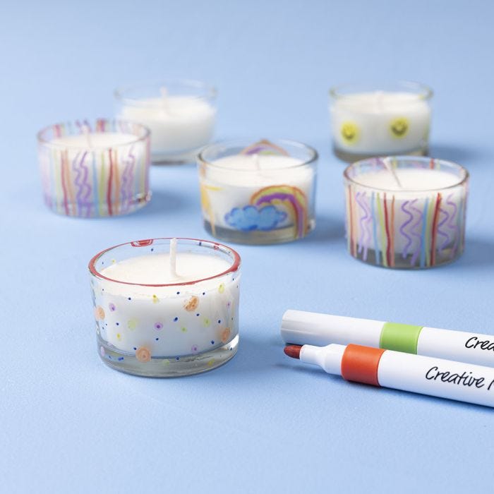 Candela colata in un portacandele e decorata con pennarelli