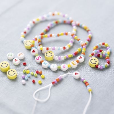 Bracciale e anelli con perline con lettere e perline con smile.