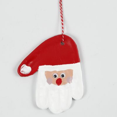 Un'impronta di mano di argilla autoindurente decorata come Babbo Natale