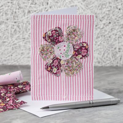 Un biglietto di auguri con un motivo floreale in tessuto cucito 