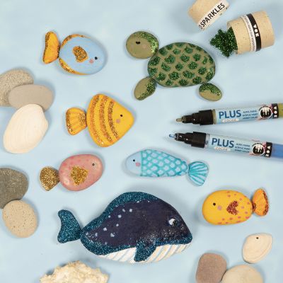 Creature marine dipinte su pietre con pennarelli e decorate con glitter bio