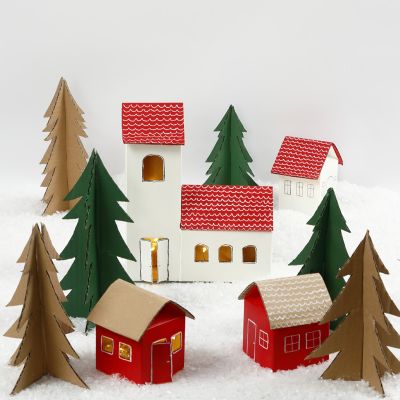 Un villaggio di Natale fatto di cartoni di latte/succhi e alberi di Natale di cartone riciclato