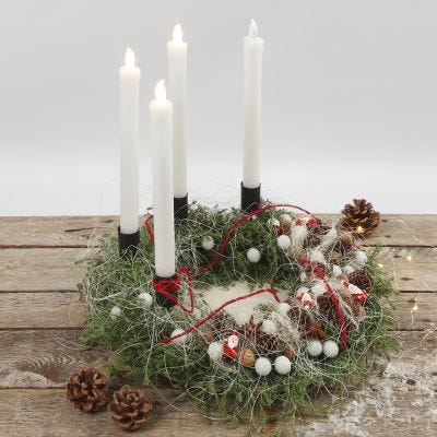 Una corona dell'Avvento decorata con materiali naturali e candele LED 