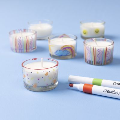 Candela colata in un portacandele e decorata con pennarelli