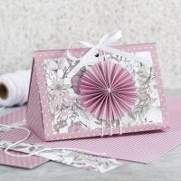 Scatola regalo rosa con coccarda e carta fantasia